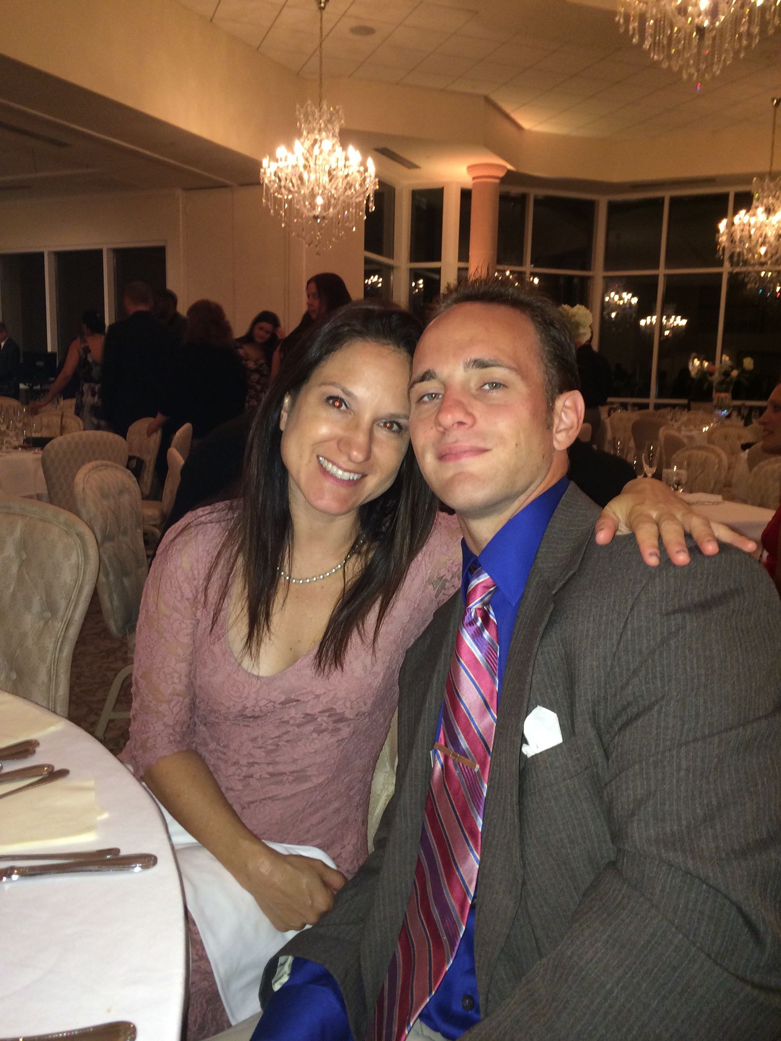 brian and michelle looking good as a couple dressed up sitting at a table at a wedding reception